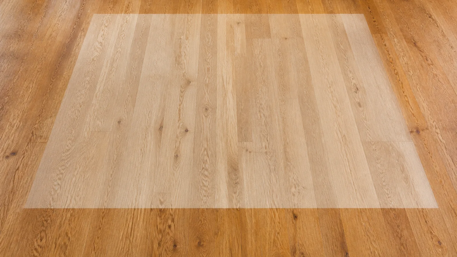 A wood floor with a clearly visible paler rectangle where an area rug used to lie, the surrounding boards darkened by years of sunlight
