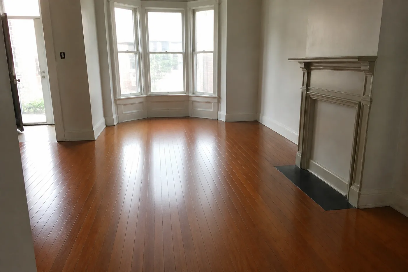 The same living room floor after a screen and recoat, with one even satin sheen throughout