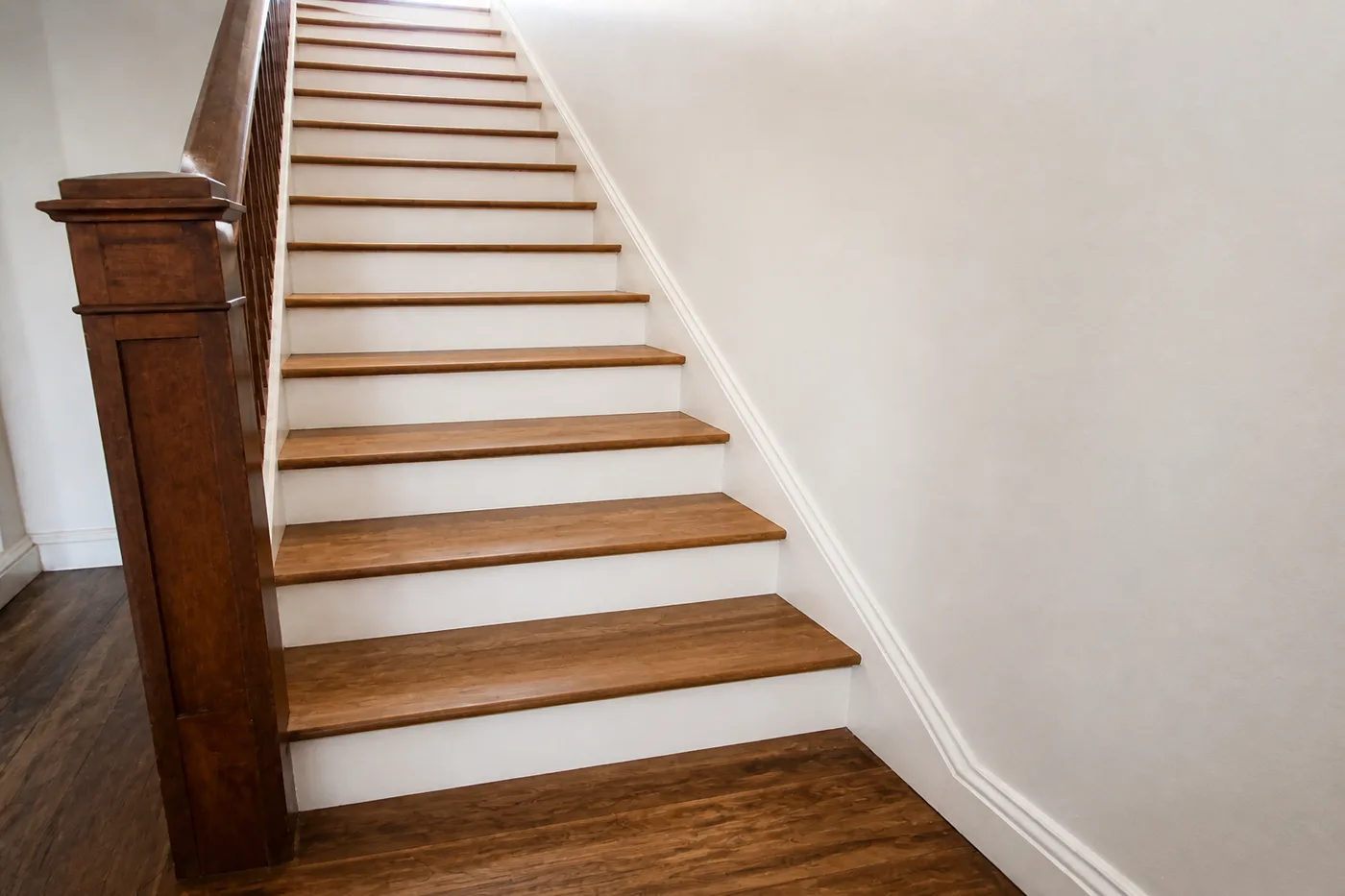 The same staircase with treads sanded and refinished and the risers repainted clean white