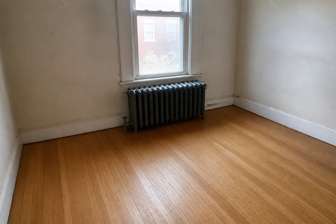 The same bedroom floor with damaged boards replaced, sanded flat and refinished